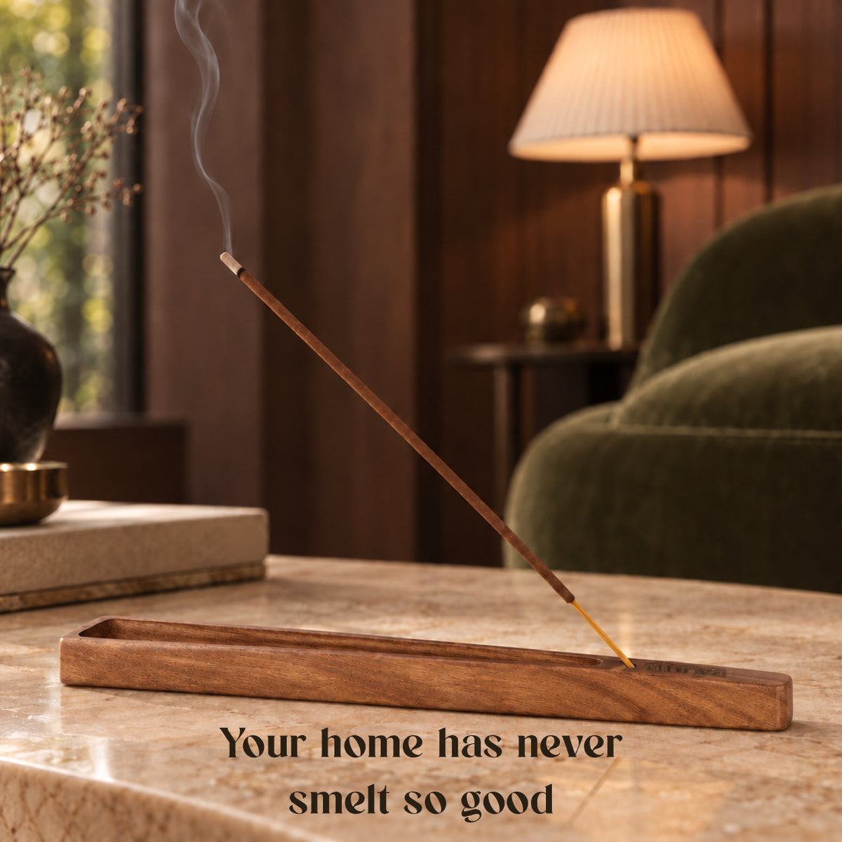 Chandara incense stick burning in a rosewood holder in a calm living room with a table lamp and sofa