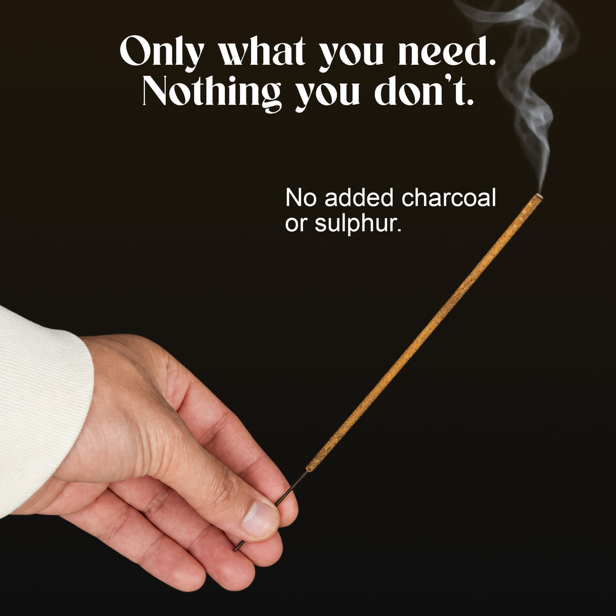 Hand holding a lit Black Oud incense stick: no added charcoal or sulphur