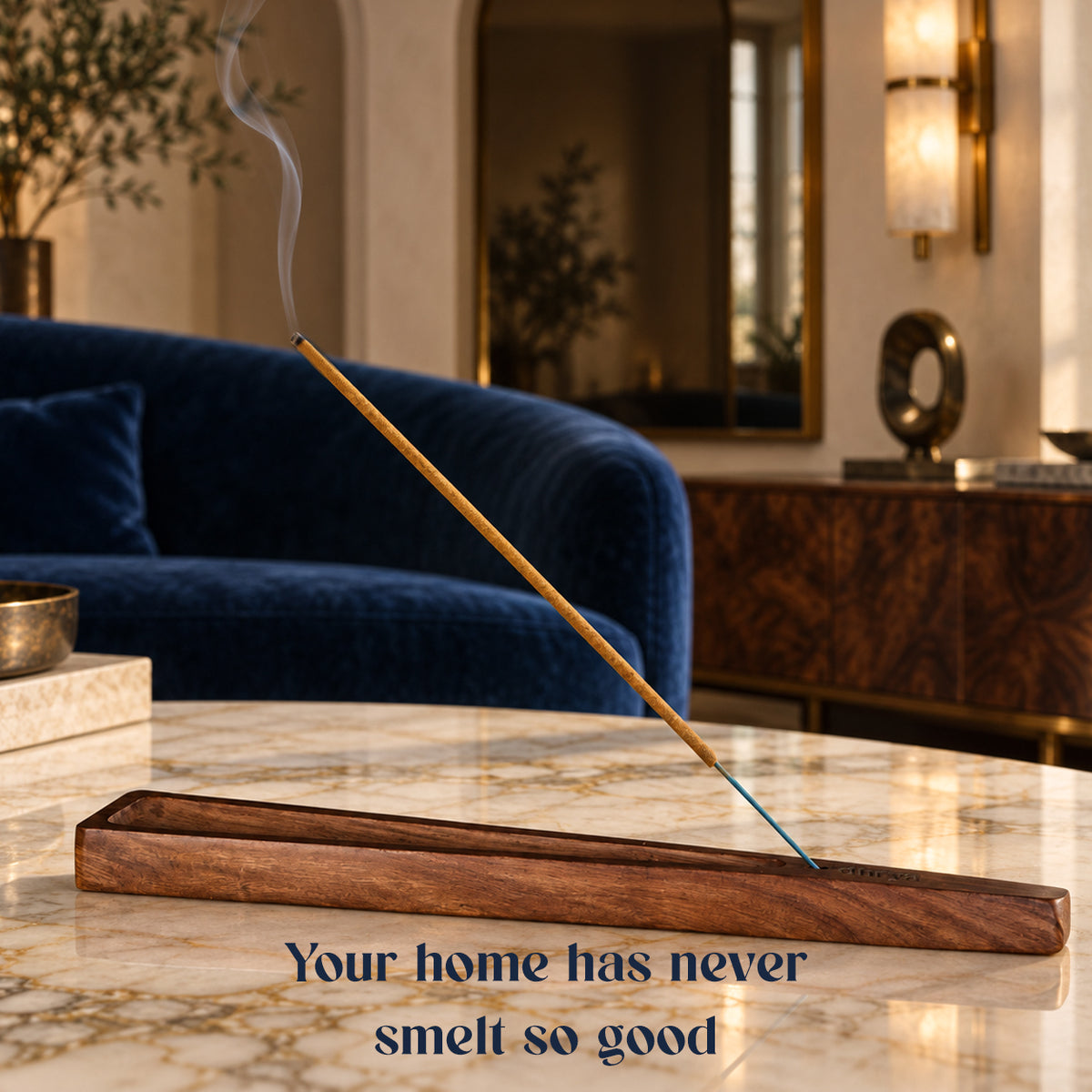 Royal Musk incense stick burning in a rosewood holder in a living room with a navy velvet sofa